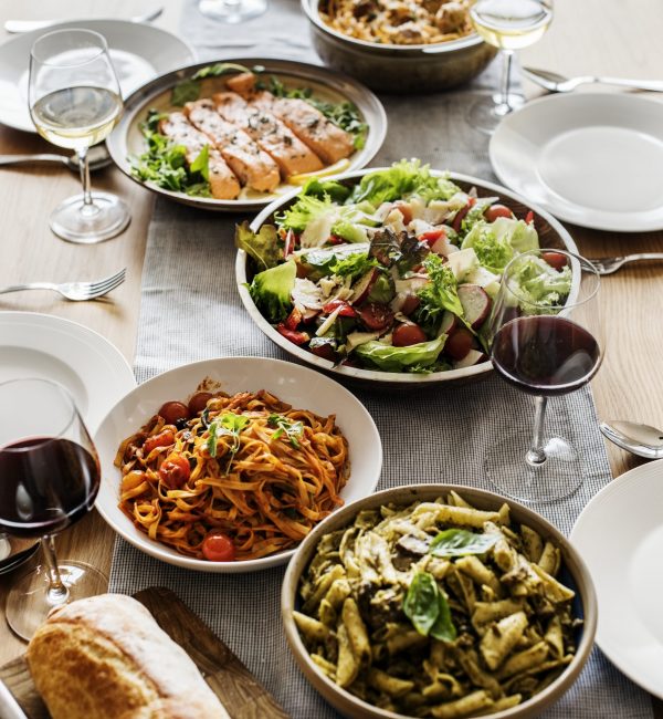 Family-style Italian dinner spread with pasta, salad and wine in Los Angeles