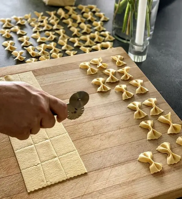 Chef hand-cutting fresh farfalle pasta